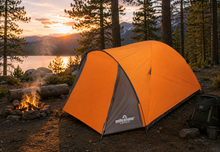 Load image into Gallery viewer, An orange and gray tent pitched at a campsite with a fire pit, trees, mountains, and a lake at sunset. The tent has the Milestone Camping logo printed on the front.