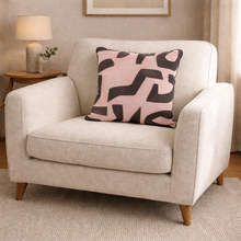 Load image into Gallery viewer, Beige armchair with a pink and black patterned pillow in a room setting.