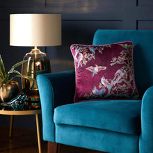 Load image into Gallery viewer, Blue armchair with a decorative pillow featuring bird patterns, next to a lamp and plant on a side table.