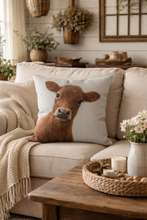 Load image into Gallery viewer, Decorative pillow with a cow design on a beige sofa in a cozy living room.