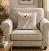 Load image into Gallery viewer, Beige armchair with a pillow featuring a swan design in a cozy living room setting.