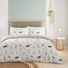 Load image into Gallery viewer, Dog patterned bedding set on a bed in a bedroom with a wooden headboard and side table.