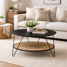 Load image into Gallery viewer, Living room with a black coffee table, white sofa, and decorative items.