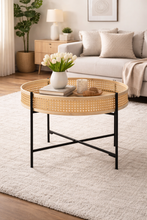 Load image into Gallery viewer, Round wicker coffee table in a living room setting with decor items.