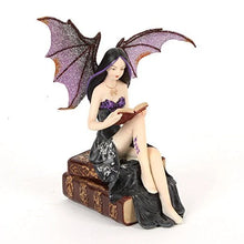 Load image into Gallery viewer, Fairy figurine with bat wings reading a book on a white background