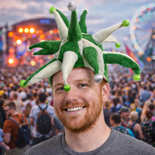 Load image into Gallery viewer, Man wearing a green and white festive hat at a lively outdoor event with colorful lights and a Ferris wheel.