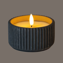 Load image into Gallery viewer, Candle in a textured black holder with a gray background