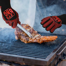Load image into Gallery viewer, Red and black silicone heat-resistant BBQ gloves with 'LET'S BBQ' printed in red on the back, shown being worn by a person grilling a large steak on a barbecue grill.