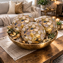 Load image into Gallery viewer, Decorative bowls with gold and silver leaf patterns on a wooden table in a living room.
