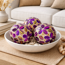 Load image into Gallery viewer, Decorative purple and gold spherical ornaments in a white bowl on a wooden table.