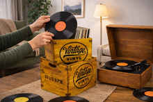 Load image into Gallery viewer, Person holding a vinyl record above a wooden 'Vintage Vinyl' crate with a record player and more records in the background.