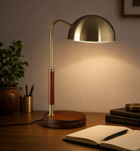 Load image into Gallery viewer, Brass desk lamp on a wooden surface with books and a plant in the background