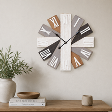 Load image into Gallery viewer, A rustic wall clock with Roman numeral cutouts on a cross-shaped frame, styled on a wooden console table with a potted plant, books, and a small vase against a neutral beige wall.