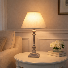 Load image into Gallery viewer, Table lamp on a round table with a vase of flowers and books in a cozy room.
