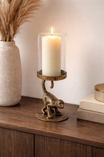 Load image into Gallery viewer, Decorative candle holder with a lit candle on a wooden surface, next to a vase with dried plants and books.
