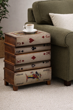 Load image into Gallery viewer, Wooden side table with playing card design next to a green sofa
