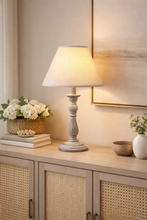 Load image into Gallery viewer, Table lamp on a wooden surface with decorative items in a home setting
