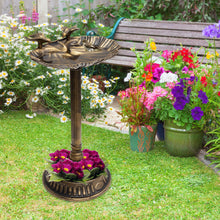 Load image into Gallery viewer, A bronze-finished garden bird bath with a pedestal base and decorative rim, placed on a green lawn in a garden setting with flowers and a wooden bench in the background.
