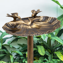 Load image into Gallery viewer, Bronze bird bath garden stake with two perched birds and a shallow scalloped dish, shown in front of green foliage.
