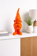 Load image into Gallery viewer, Orange gnome figurine on a white surface with a wooden cabinet and plant in the background
