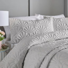 Load image into Gallery viewer, Gray textured comforter on a bed with pillows and a lamp in a bedroom setting.

