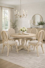 Load image into Gallery viewer, Dining room with round table and chairs, chandelier, and decor elements.
