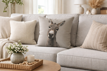 Load image into Gallery viewer, Gray sofa with a pillow featuring a donkey face, placed in a cozy living room.
