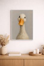 Load image into Gallery viewer, Framed artwork of a duck on a wall above a wooden cabinet with decorative items.
