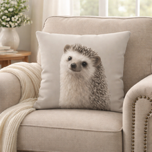 Load image into Gallery viewer, Pillow with a hedgehog design on a beige armchair in a cozy living room.
