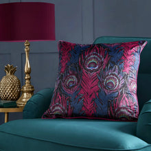 Load image into Gallery viewer, Decorative pillow with peacock feather pattern on a teal sofa, with a lamp and decorative pineapple in the background.
