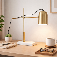 Load image into Gallery viewer, Gold desk lamp on a wooden desk with a notebook, pen, plant, and coffee cup.
