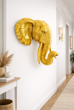 Load image into Gallery viewer, Gold elephant head wall decoration in a home interior setting.
