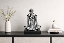 Load image into Gallery viewer, Decorative statue of a person in a meditative pose on a black shelf with minimal decor.
