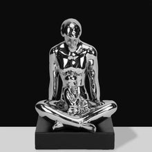 Load image into Gallery viewer, Chrome sculpture of a seated figure on a black base against a black background
