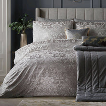 Load image into Gallery viewer, Gray patterned bedding set on a bed with decorative pillows against a dark wall.
