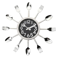 Load image into Gallery viewer, A novelty wall clock shaped like a dining fork and spoon arrangement, featuring a black face with white numbers and silver utensil hands on a plain white background.
