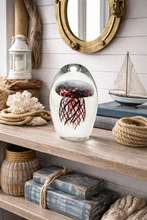 Load image into Gallery viewer, Decorative shelf with a glass orb, books, and nautical items.
