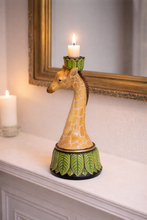 Load image into Gallery viewer, Giraffe-shaped candle holder with a candle on a surface, with a mirror in the background.
