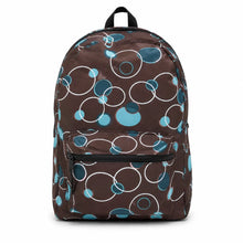 Load image into Gallery viewer, A brown backpack featuring an all-over abstract pattern of overlapping circles in white, teal, and light blue, with black zippers and a black top handle, shown against a plain white background.
