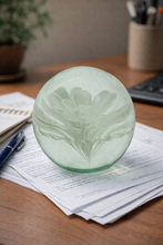 Load image into Gallery viewer, Decorative green glass object on top of paperwork with a blurred background
