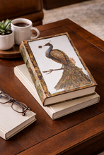 Load image into Gallery viewer, Decorative box with peacock design on a wooden table with books and glasses.
