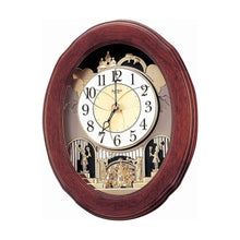 Load image into Gallery viewer, An oval wooden wall clock with a reddish-brown wood frame, featuring a cream-colored face, black Arabic numerals, and ornate gold-toned figurine details on a white background.
