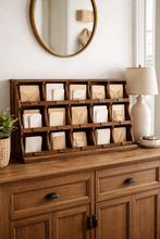 Load image into Gallery viewer, Wooden dresser with a decorative shelf holding small boxes, a lamp, and a mirror on the wall.
