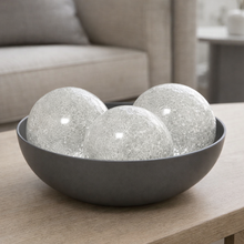 Load image into Gallery viewer, Decorative bowl with three glass spheres on a wooden table in a living room setting.
