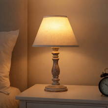 Load image into Gallery viewer, Table lamp on a nightstand with a warm glow in a bedroom setting
