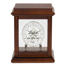 Load image into Gallery viewer, A wooden mantel clock with a polished dark brown wood case, clear glass front panel, and visible skeletonized clock face showing ornate hands and inner gears.
