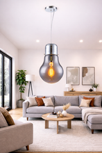 Load image into Gallery viewer, Modern living room with a large hanging light bulb fixture.
