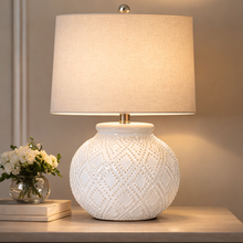 Load image into Gallery viewer, White textured table lamp with a beige lampshade on a wooden surface.
