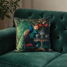 Load image into Gallery viewer, Decorative pillow with peacock and floral design on a green velvet couch.
